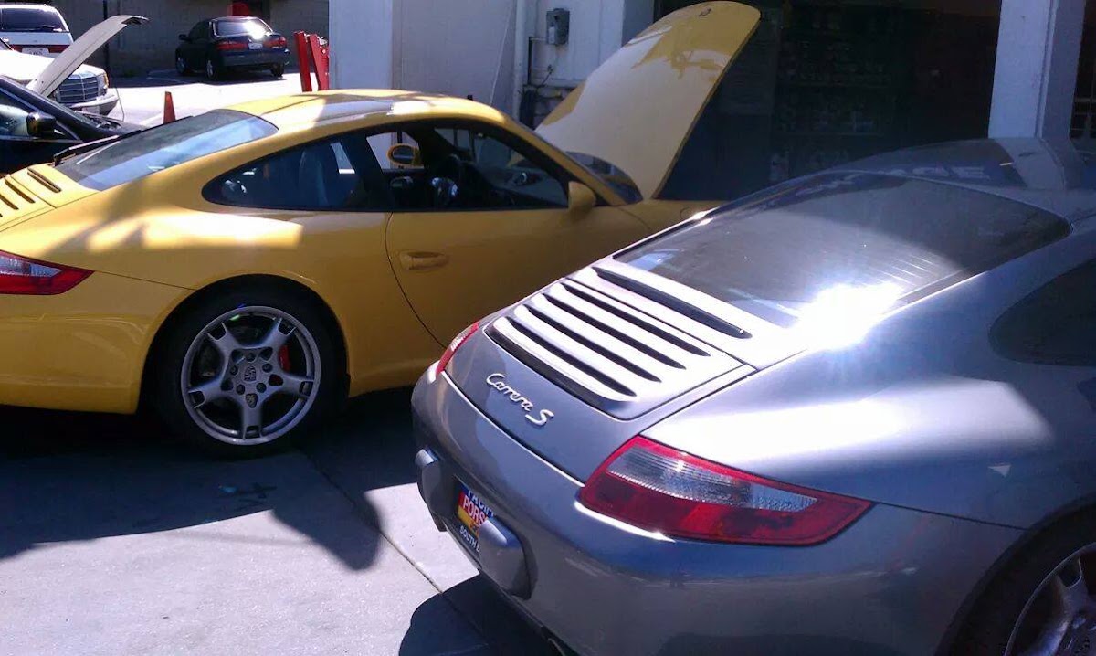 Two Porsche 911s, one yellow and one silver Carrera S, at Nery's Auto Repair